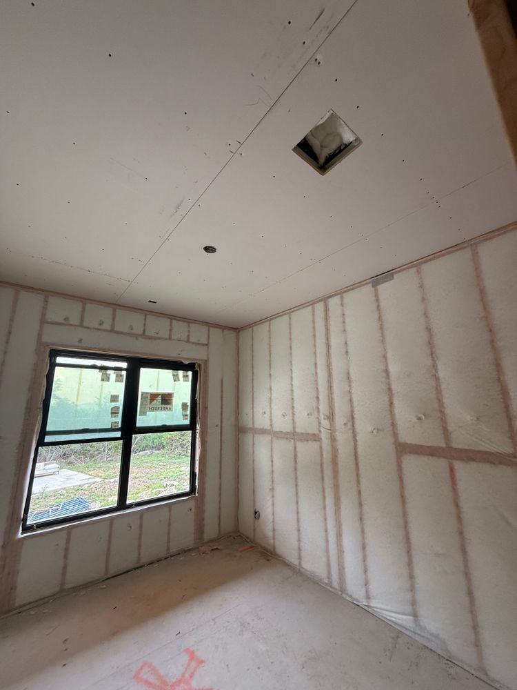 Empty unfinished room with drywall, a window, and ceiling vent openings.
