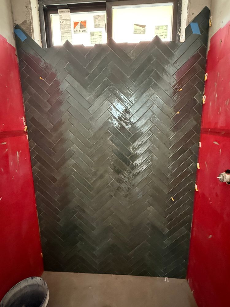 Black herringbone-patterned barrier between red walls, with small windows above.