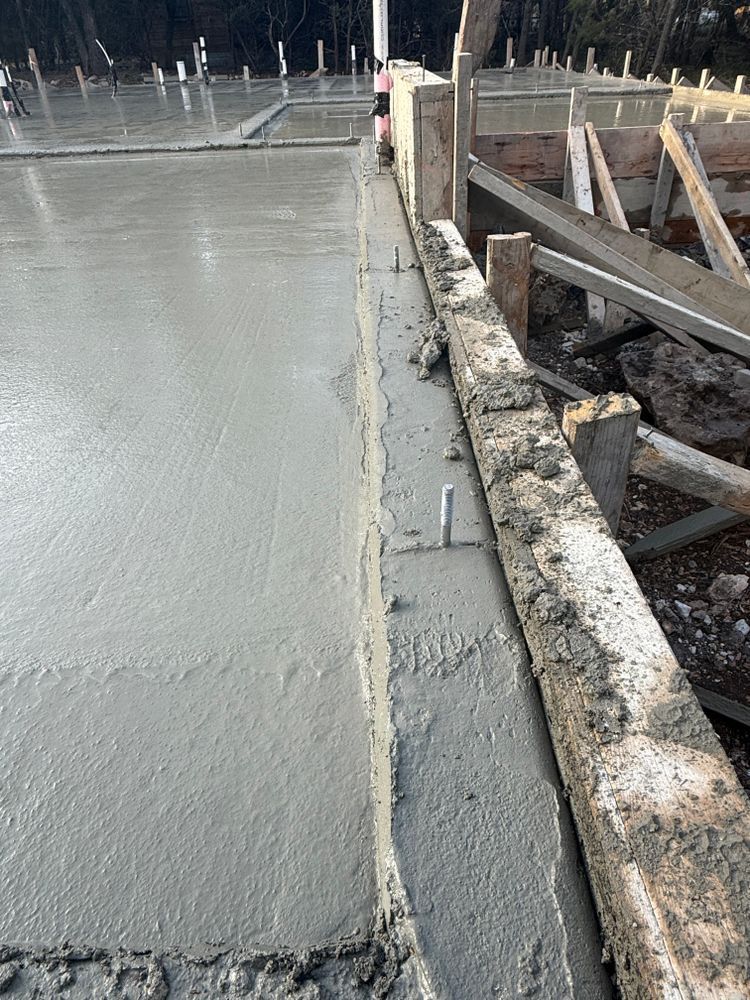 Fresh concrete slab beside a wooden formwork and rebar on a construction site