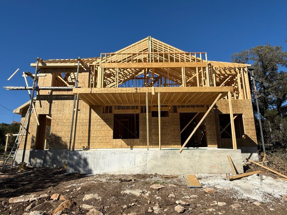 Partially framed house under construction with exposed wood framing and concrete foundation