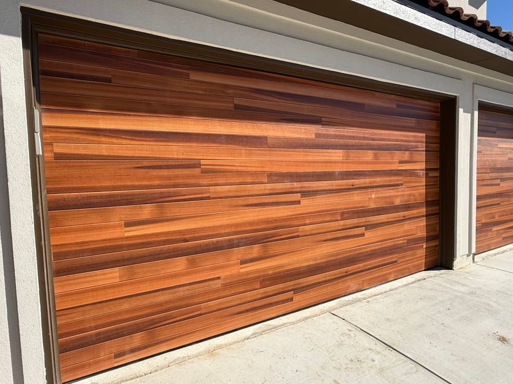 Modern wooden garage doors with horizontal slats beside a concrete driveway