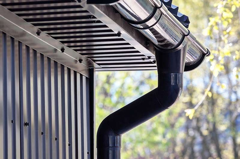 A Close Up of a Black Gutter on the Side of a Building — Affordable Plumbing In Port Macquarie, NSW