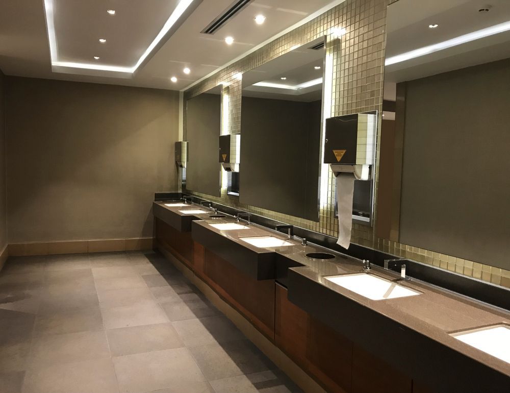 Modern public restroom with a long vanity — Affordable Plumbing In Port Macquarie, NSW