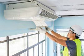Man Installing an Air Conditioning Unit — HVAC in Dunn, NC