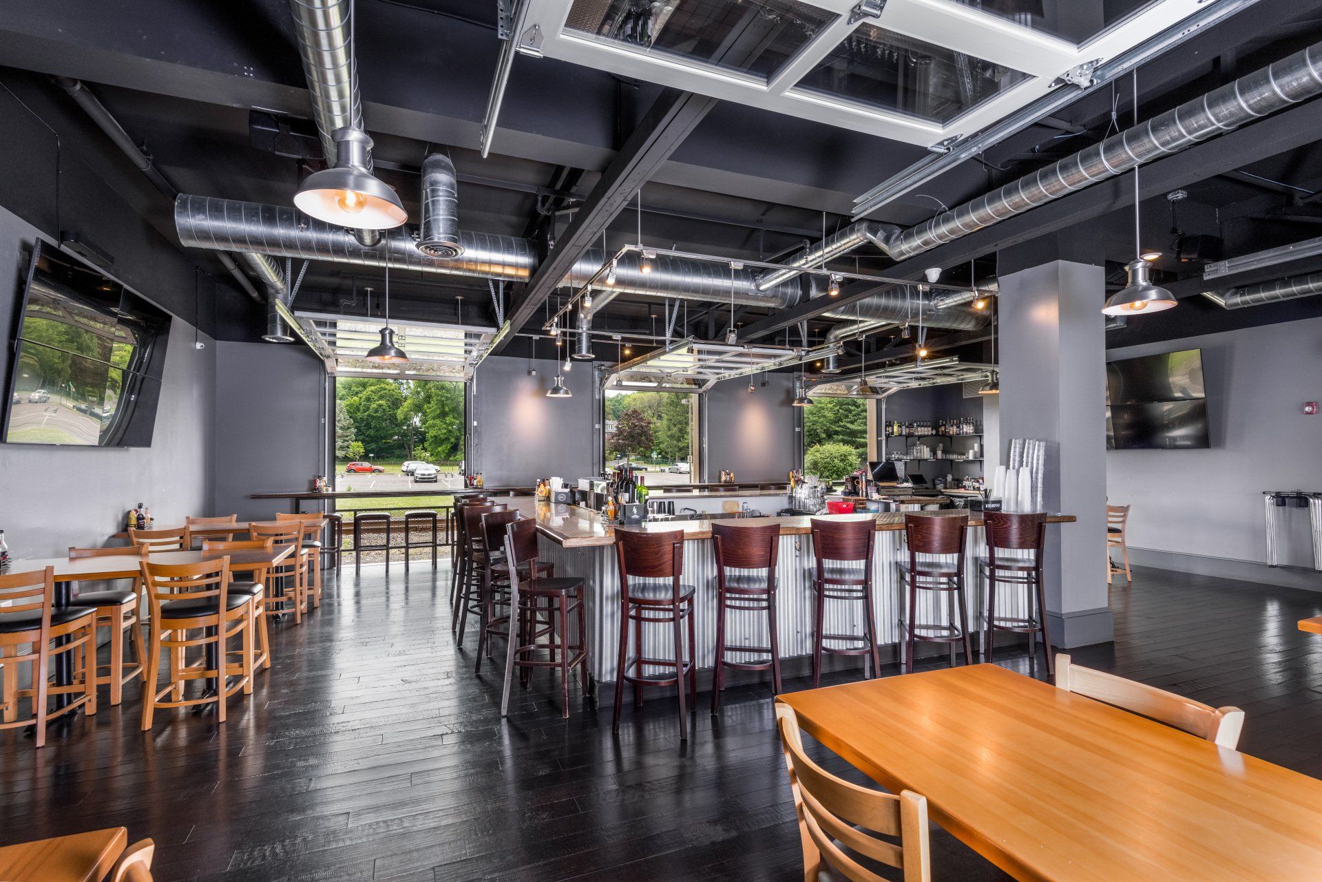 A large dining room with tables and chairs and a bar.