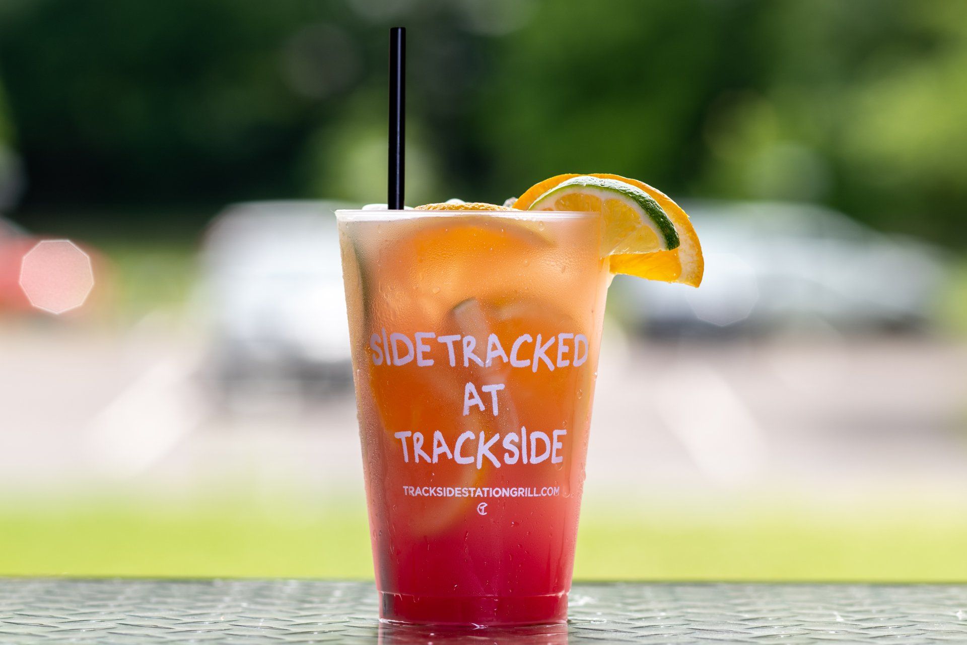 A drink in a plastic cup with a straw on a table.