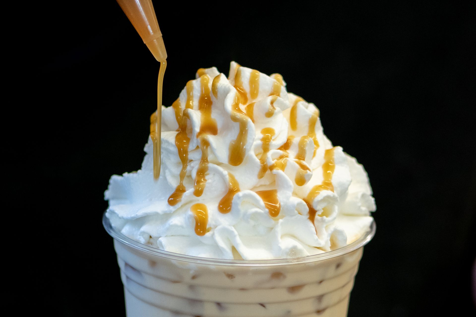 A milkshake with whipped cream and caramel sauce on top.