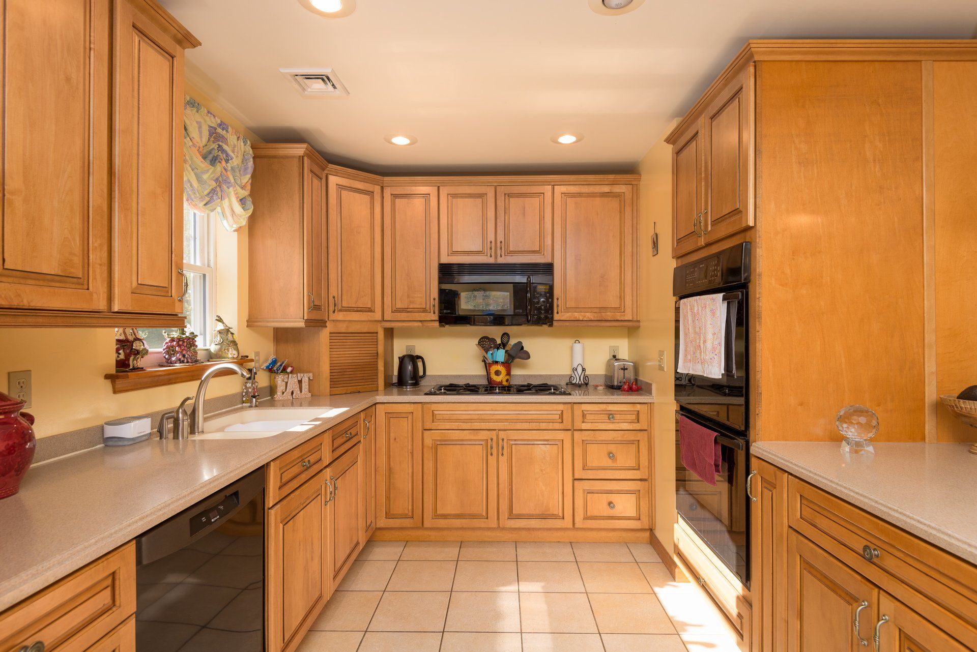 A kitchen with wooden cabinets and white counter tops