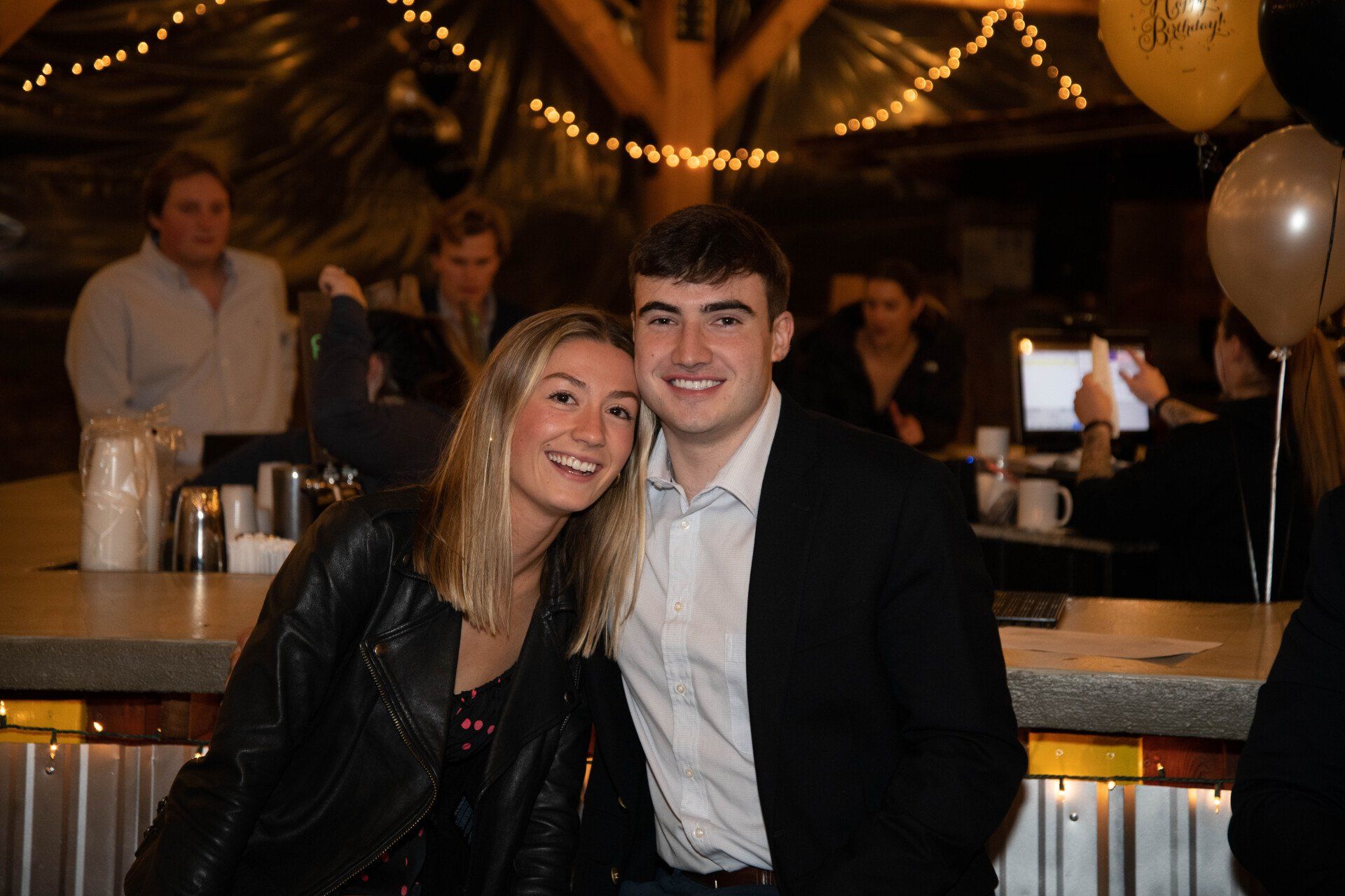 A man and a woman are posing for a picture in a restaurant.