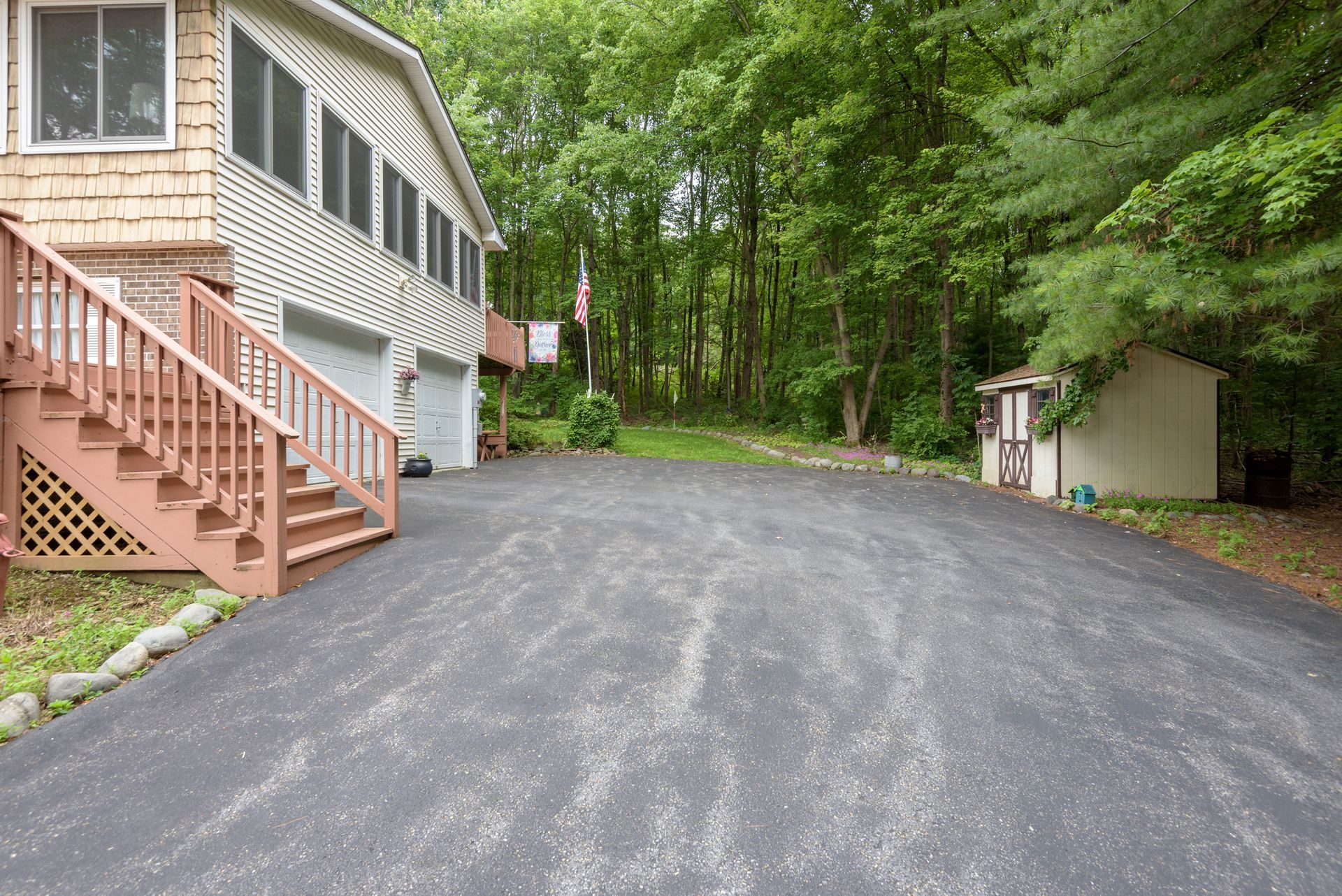 A house with stairs and a driveway in front of it