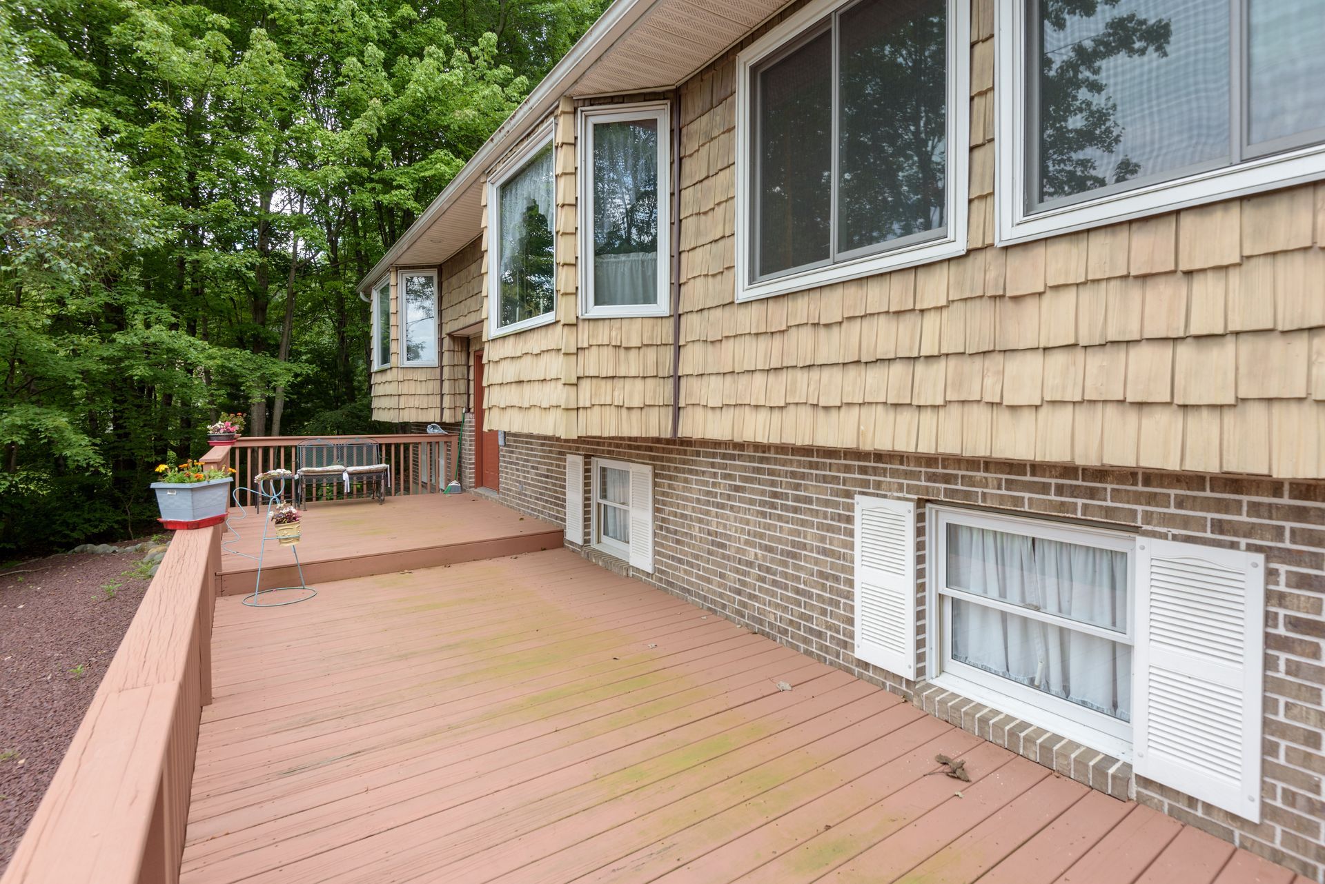 A house with a large deck and a lot of windows.