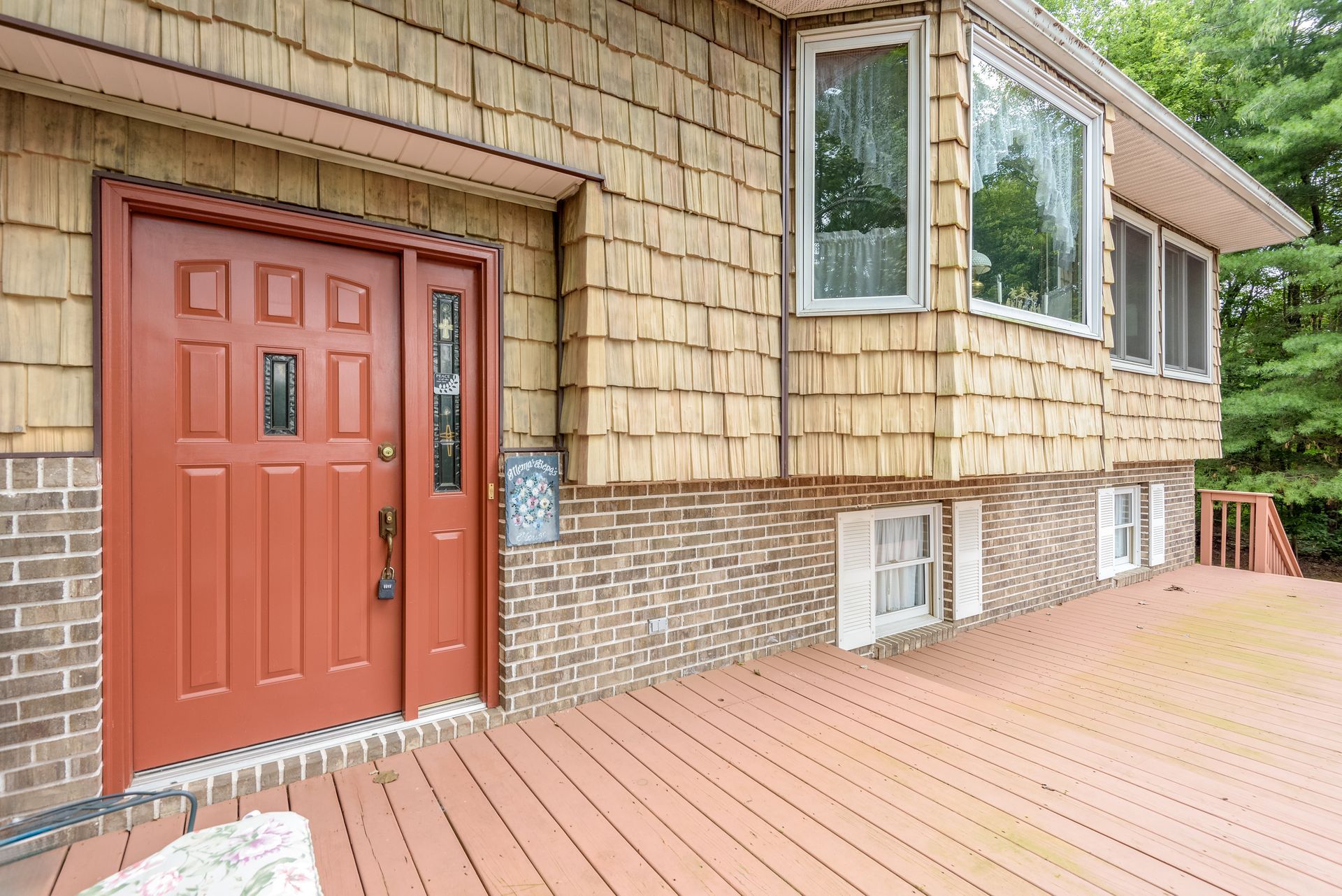 A large house with a red door and a wooden deck