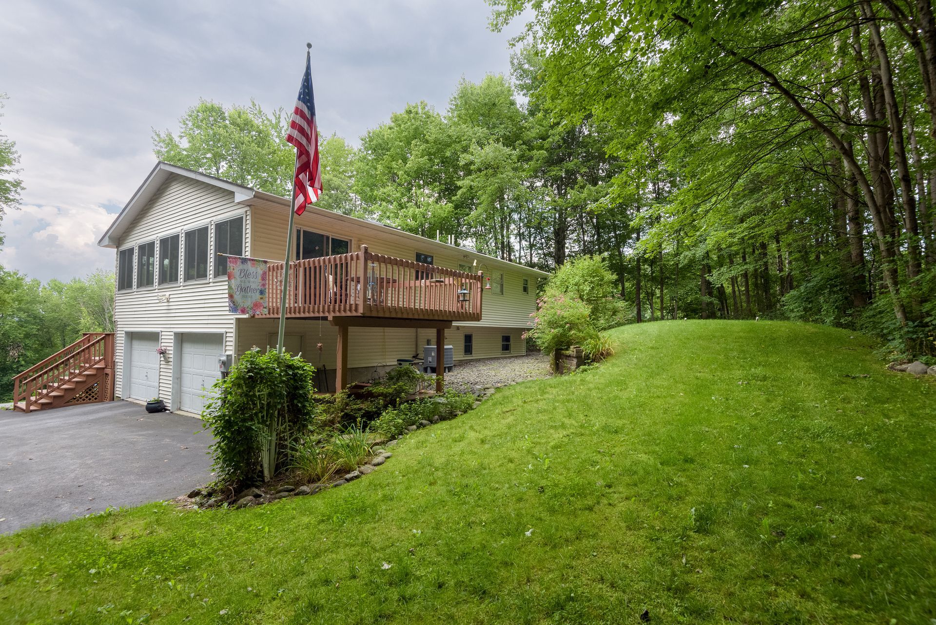 A house with a large lawn in front of it and an american flag.