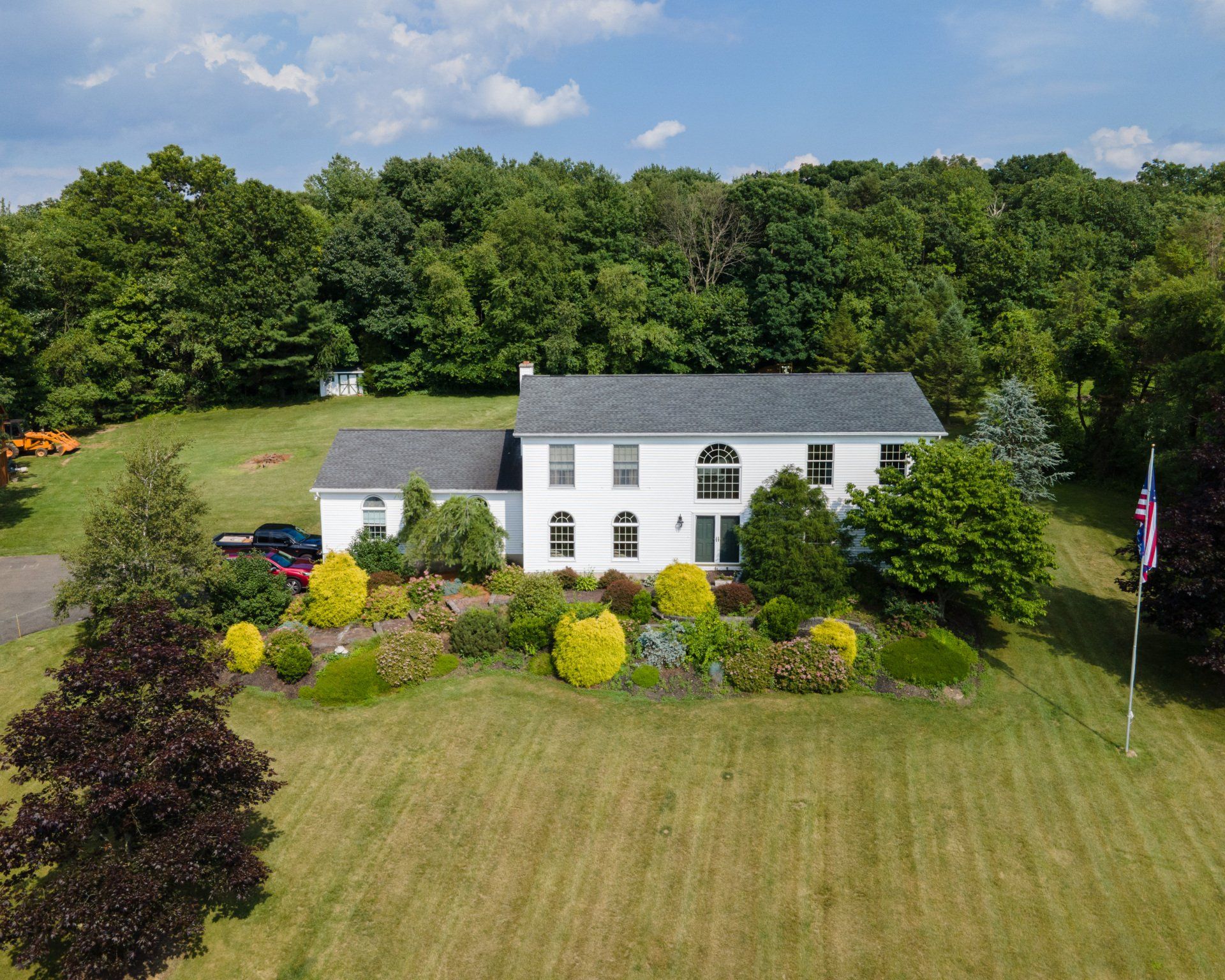 An aerial view of a large white house surrounded by trees