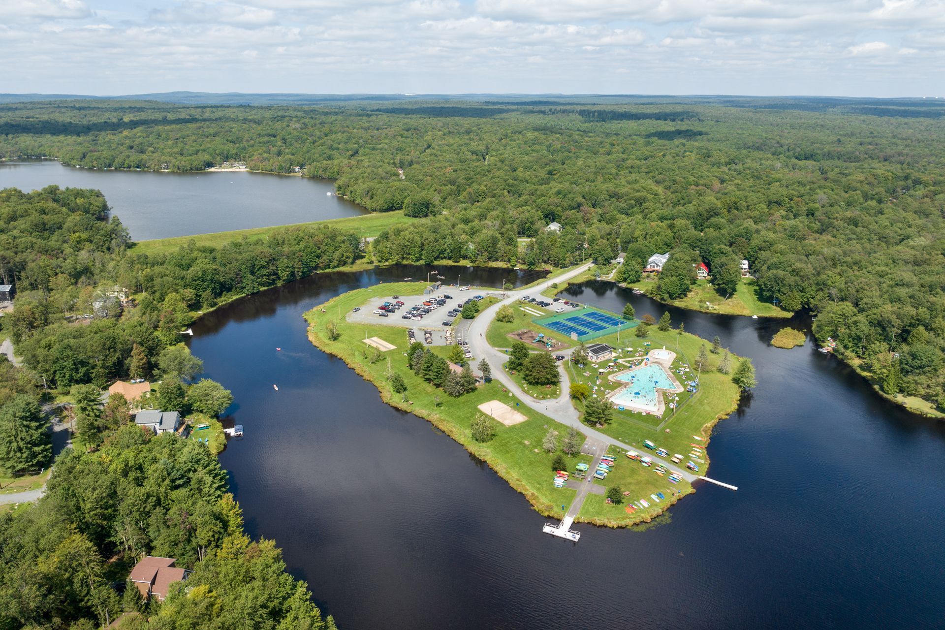 An aerial view of a small island in the middle of a lake surrounded by trees.