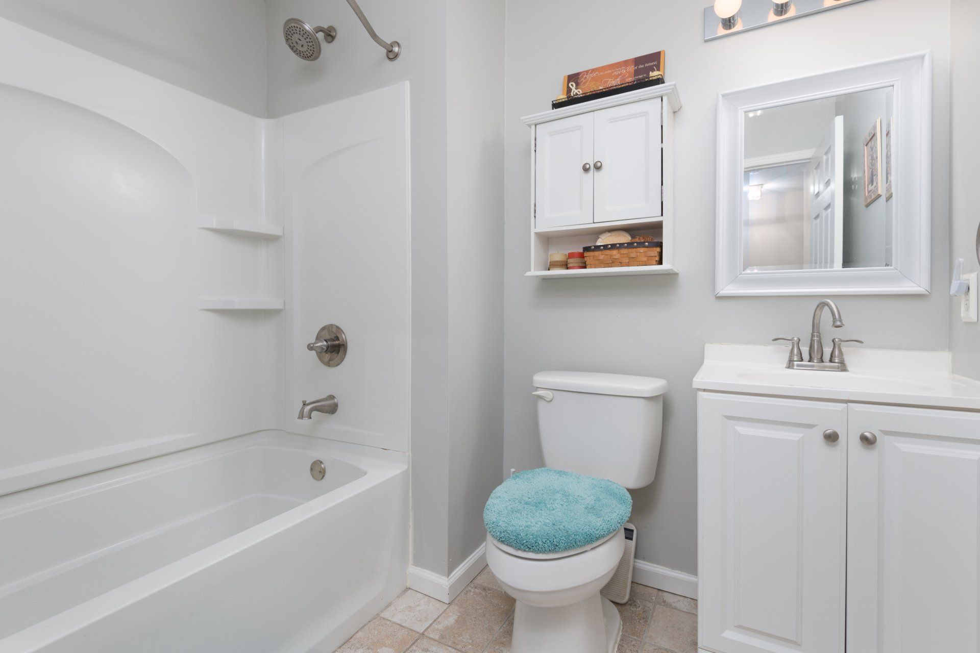 A bathroom with a toilet , sink , bathtub and mirror.