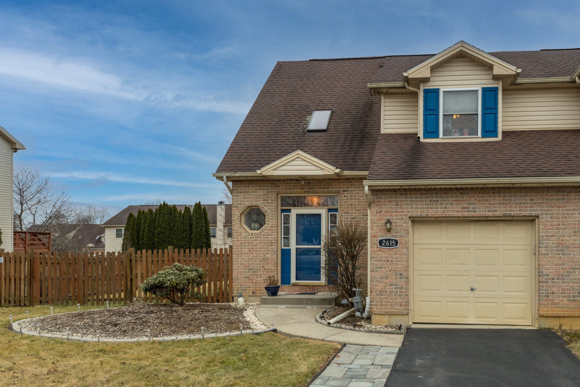 A brick house with a garage and a blue door
