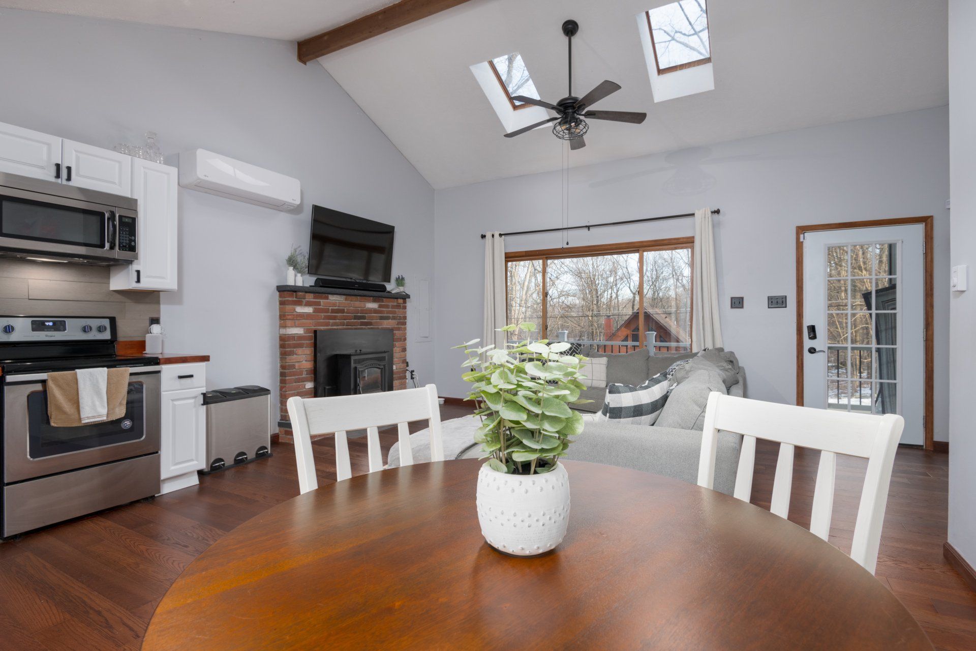 A dining room table with a potted plant on it in a living room.