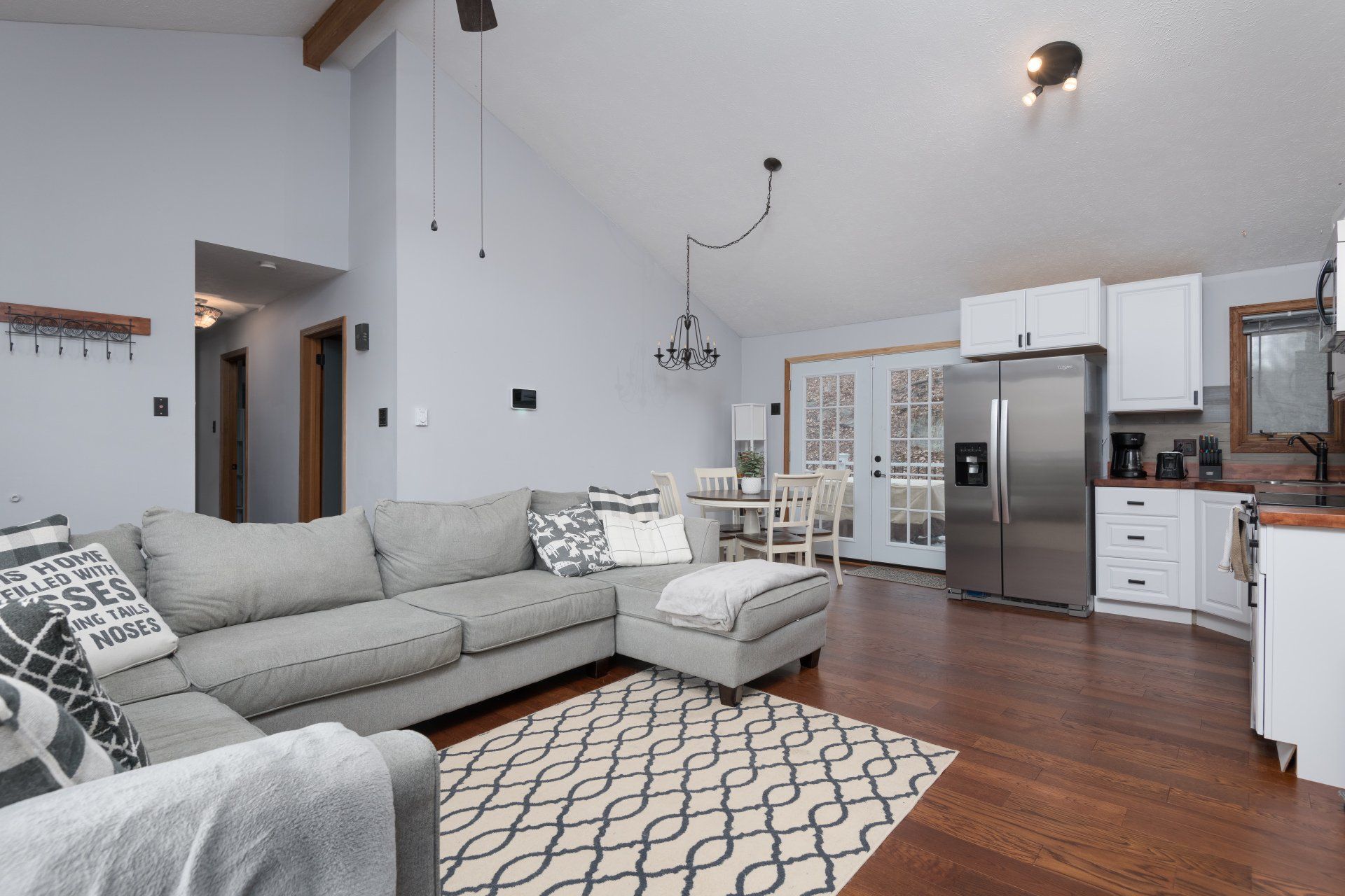 A living room with a large sectional couch and a rug.