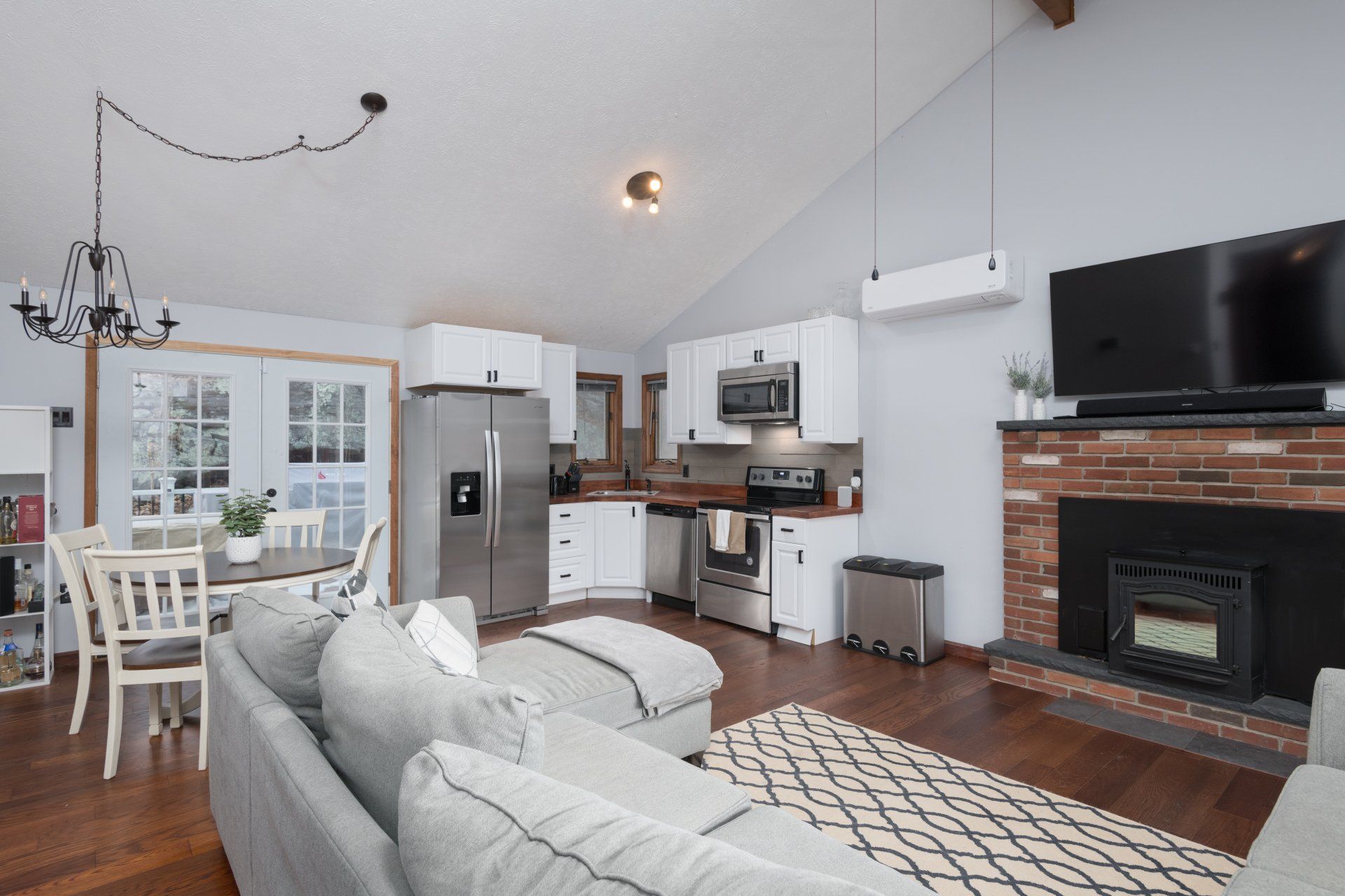 A living room with a couch , fireplace , television and refrigerator.