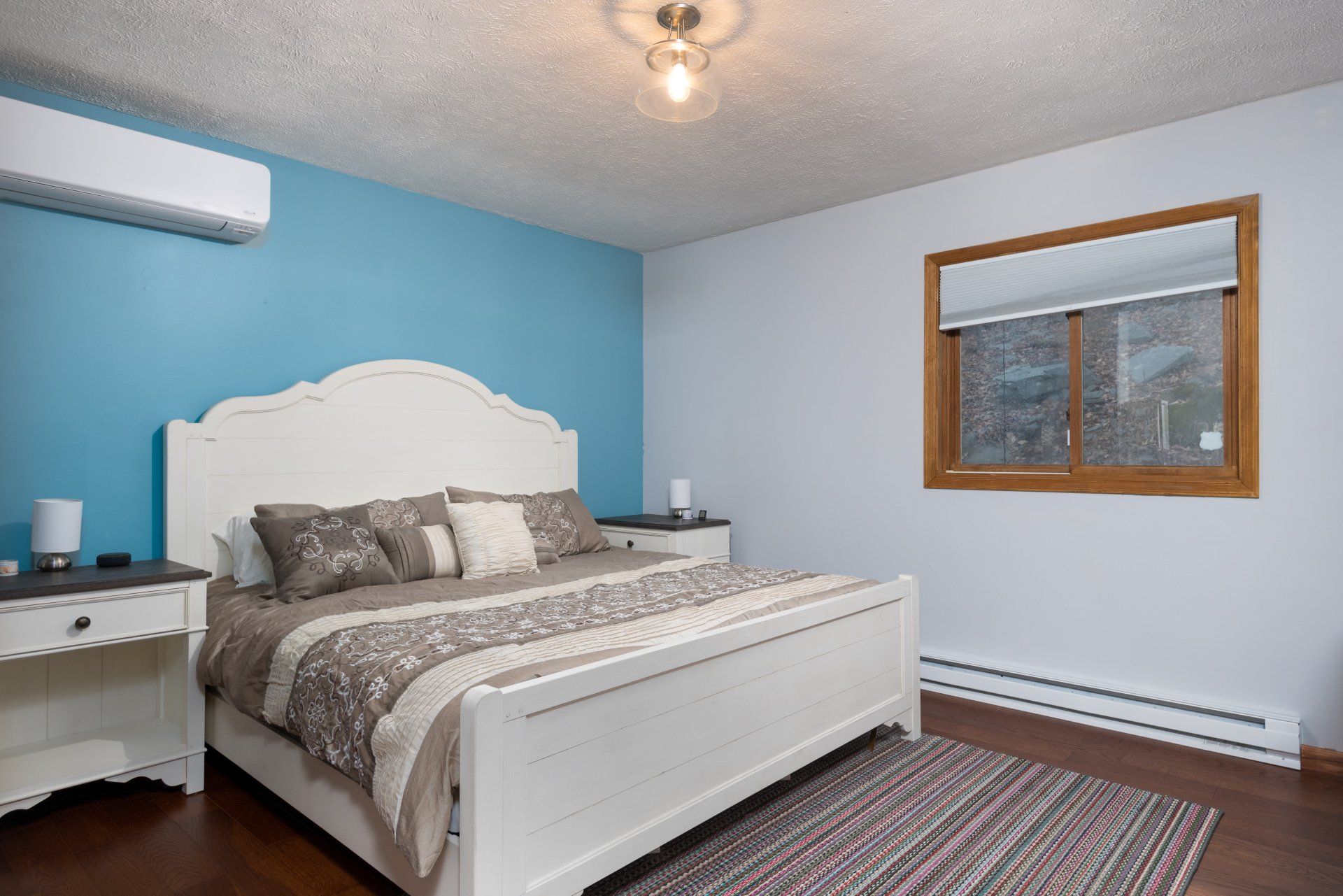 A bedroom with a king size bed , nightstands , and a window.