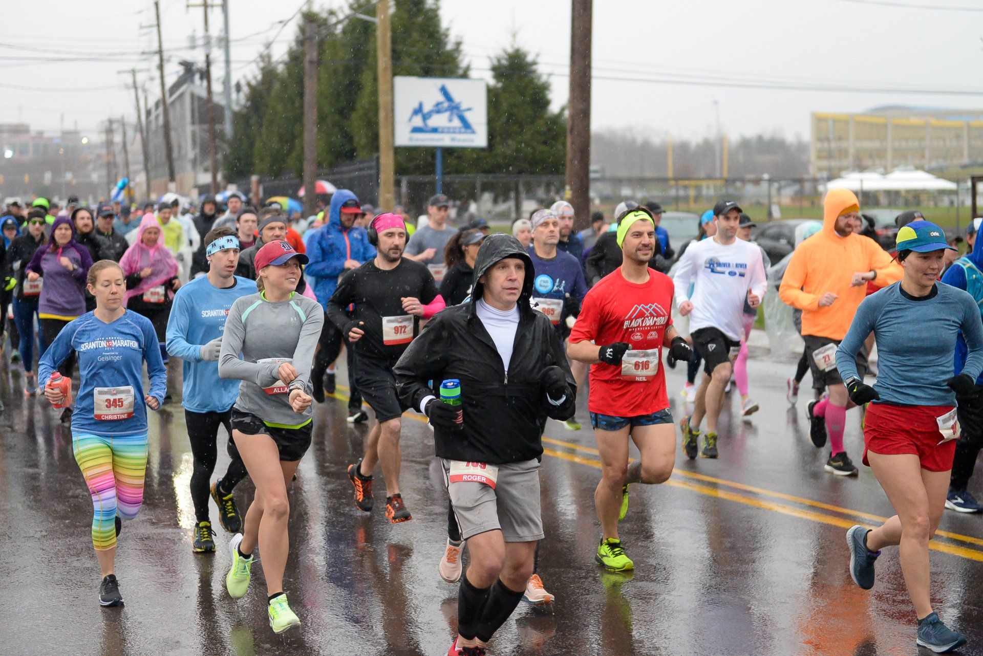 A group of people are running a marathon in the rain.