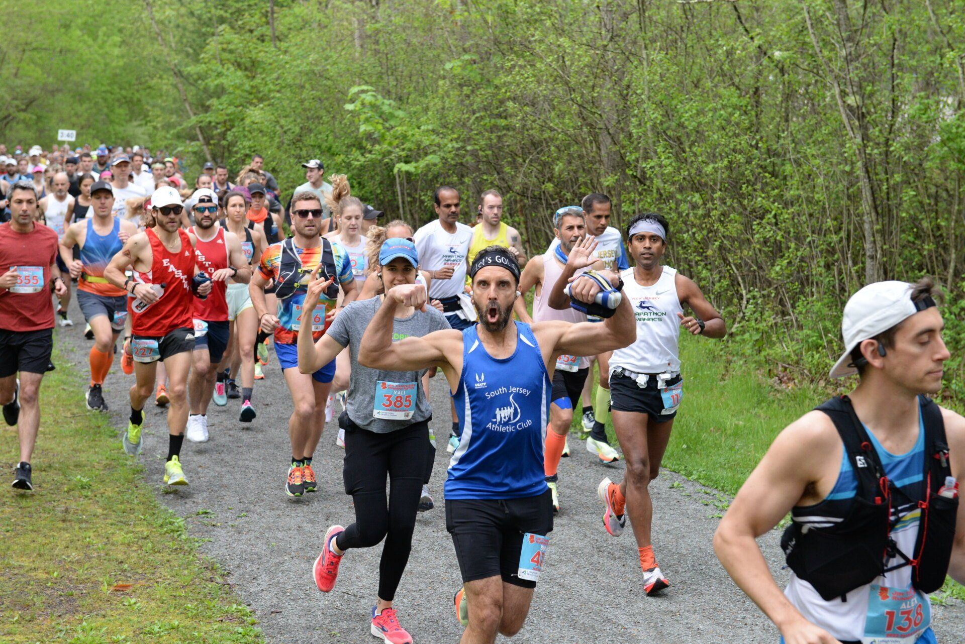 A group of people are running a marathon on a dirt path.
