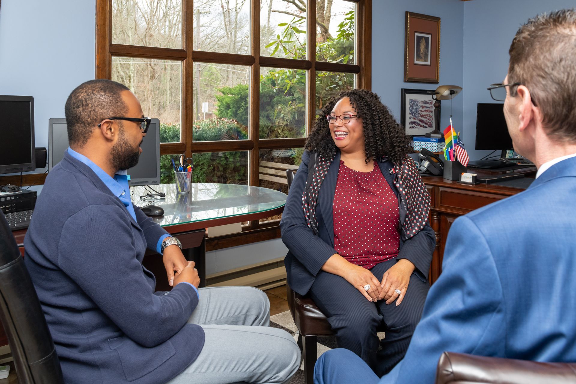 A group of people are sitting in a room talking to each other.