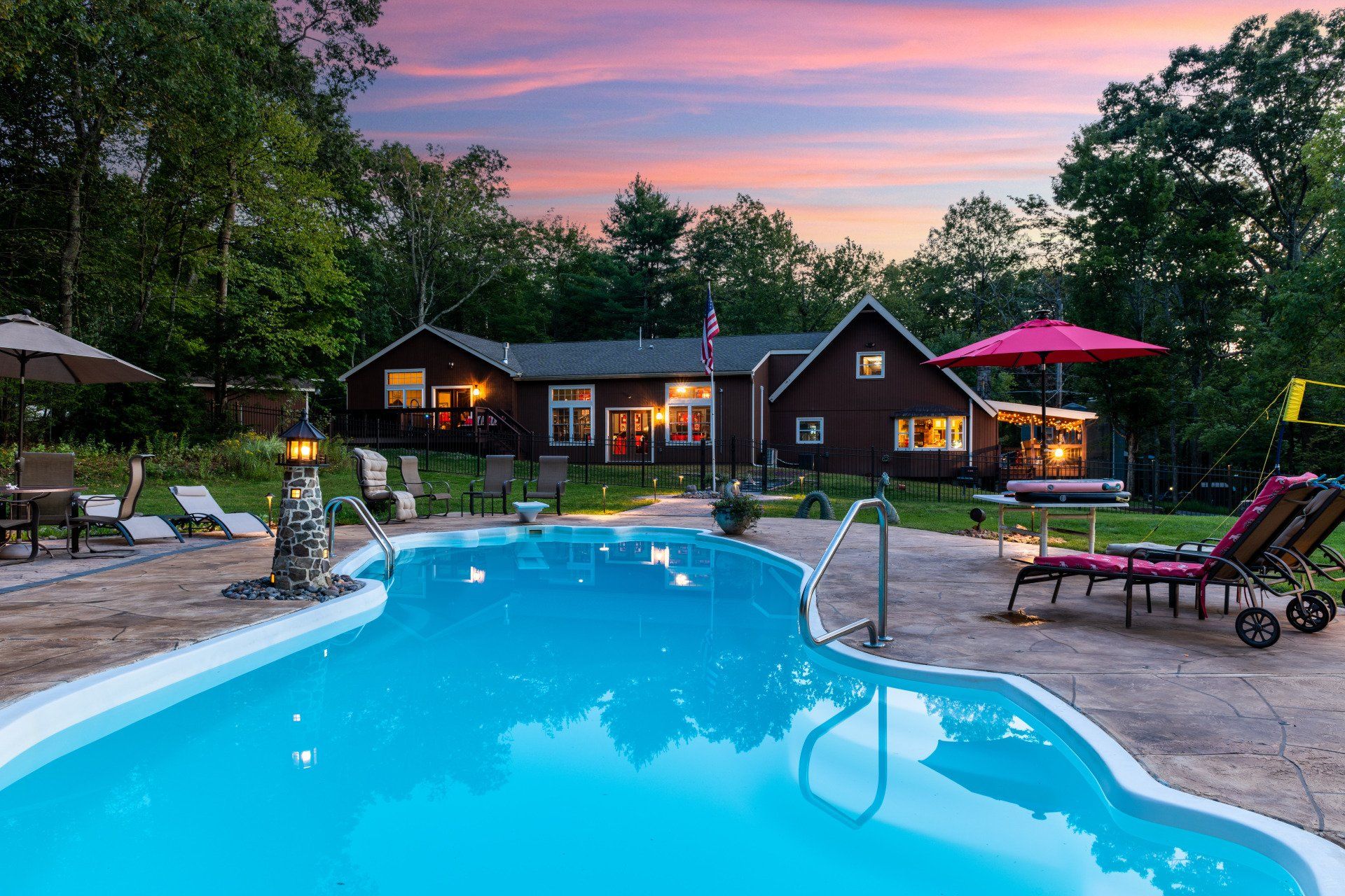 There is a large swimming pool in front of a house.