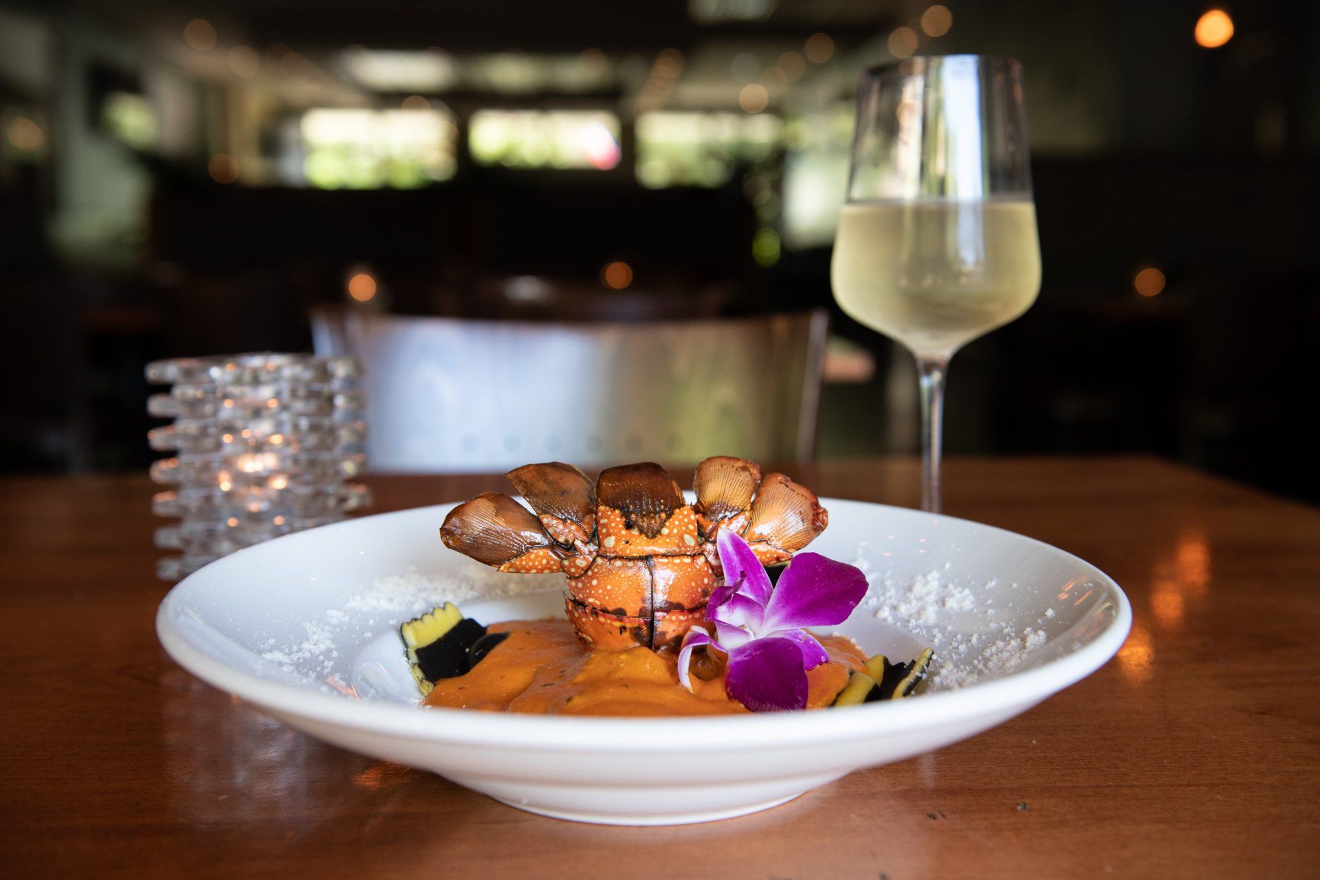A plate of food and a glass of wine on a table.