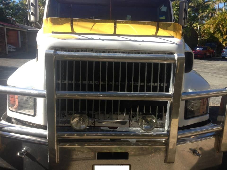 White semi-truck front with chrome grill and lights. Yellow visor. Parked outside. — Mechanic in Park Ridge, QLD