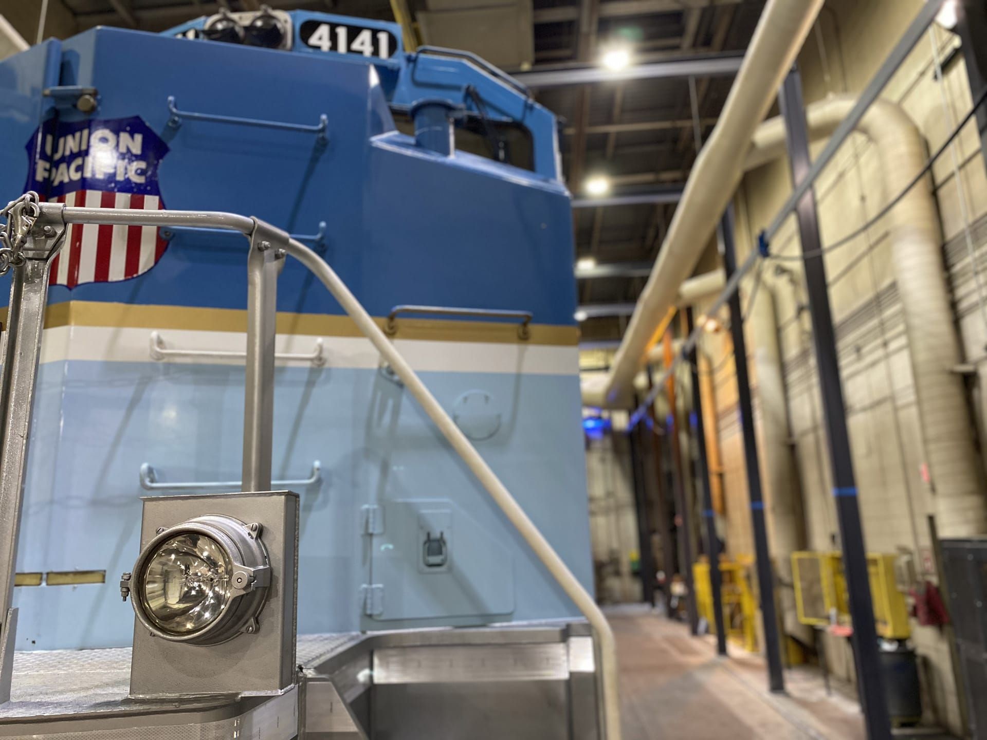 Blue and gold Union Pacific locomotive, inside a building.
