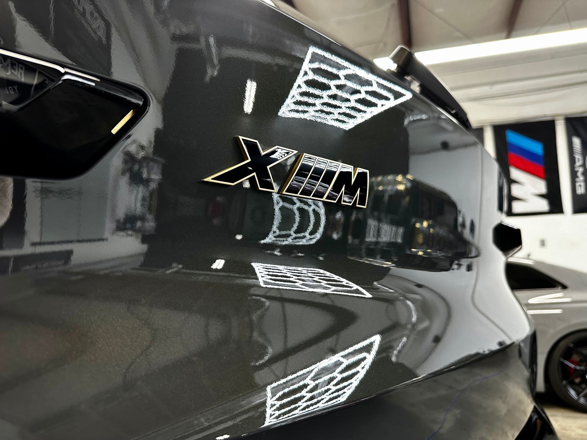Train car 1616 inside a train depot. People walking. Red, black, and gold details on the car.