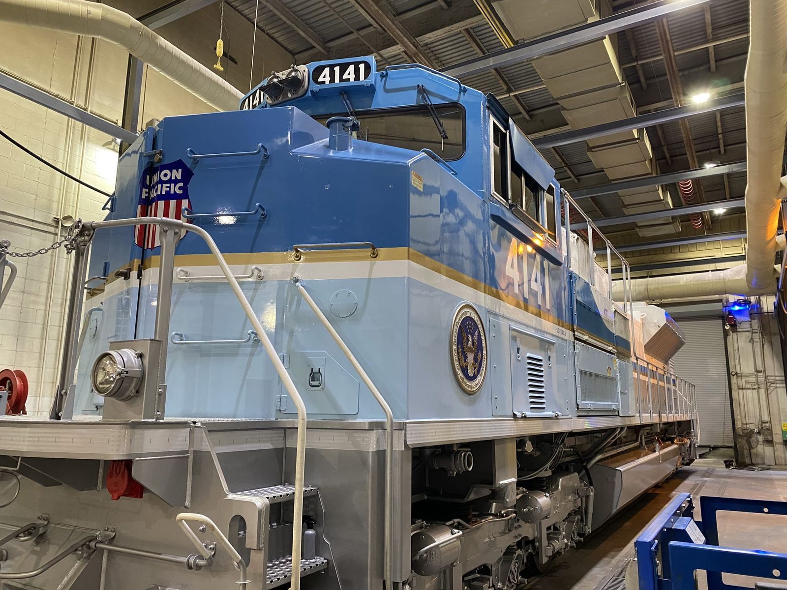 Blue and silver locomotive, number 4141, in a maintenance shed.