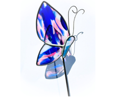 Stained glass art in a shop window, including a face, tree, and other colorful designs.