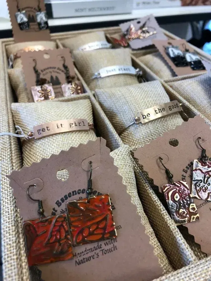 Jewelry display: earrings and bracelets with inspirational quotes in a divided tray.