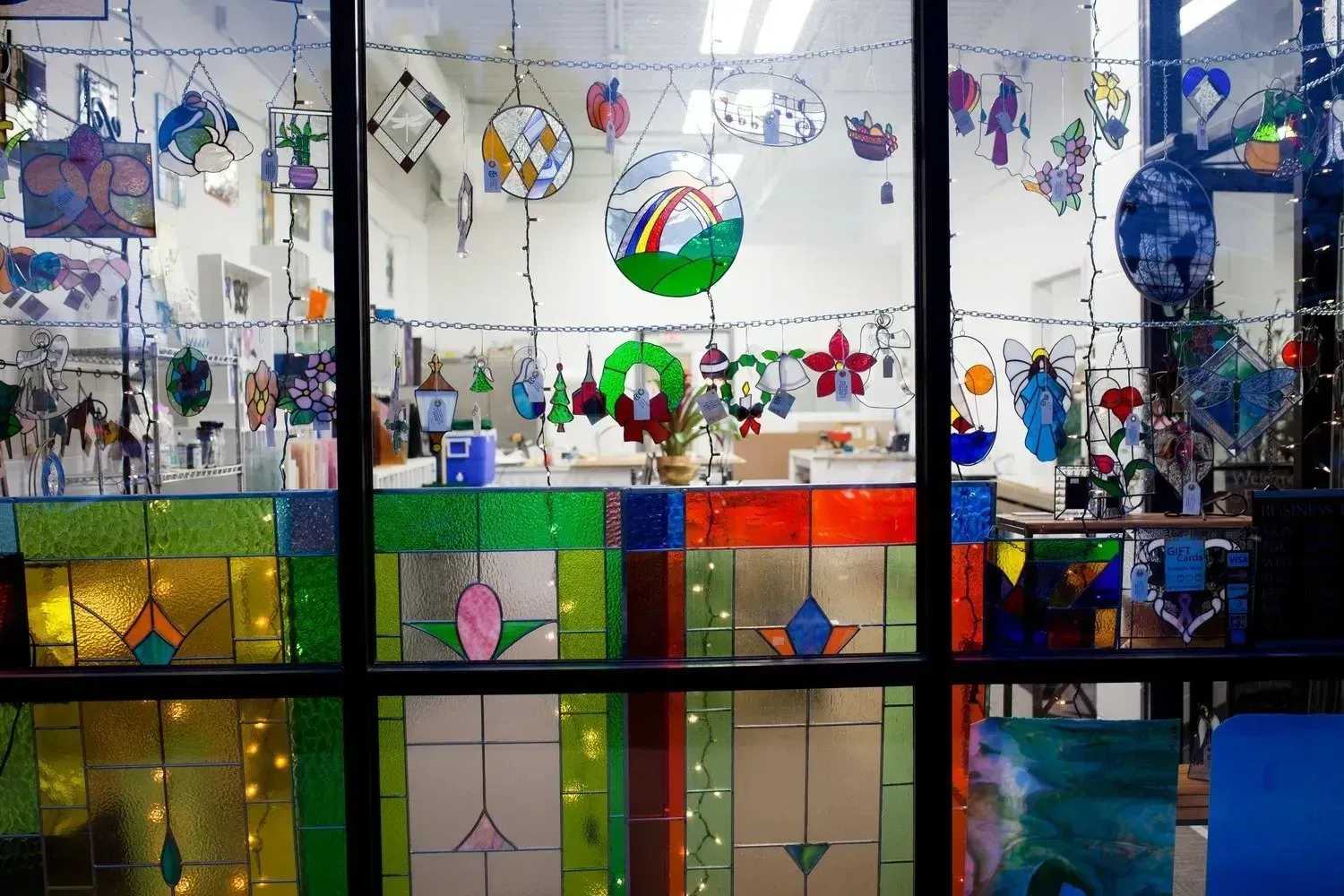 Window display of colorful stained glass and hanging art.