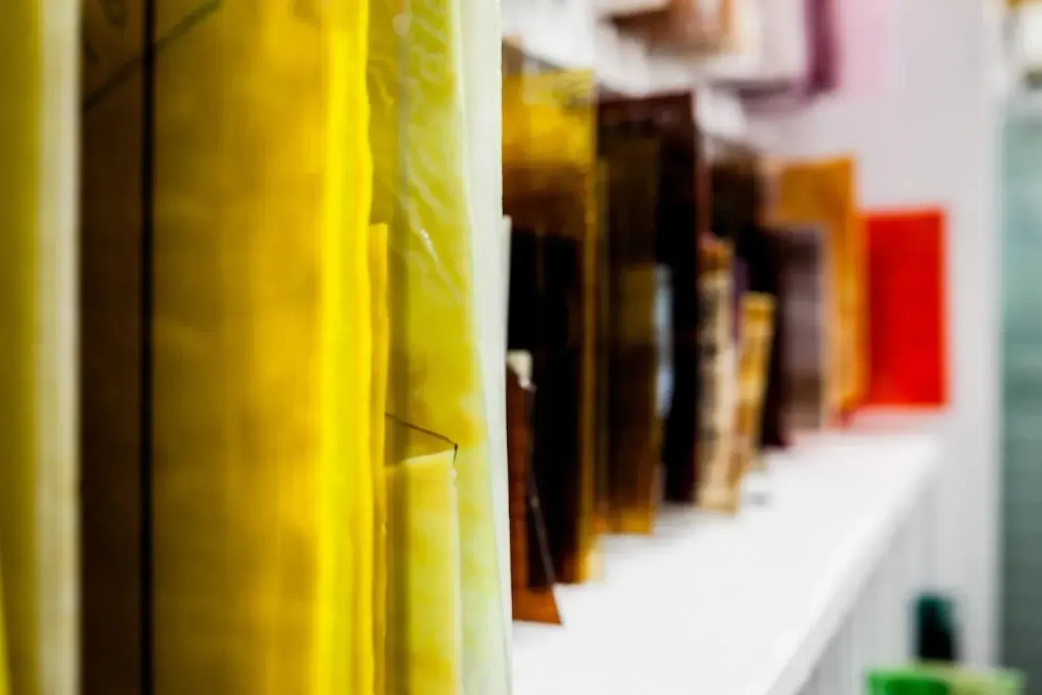 Row of packaged products on a white shelf, with yellow and brown packaging visible.