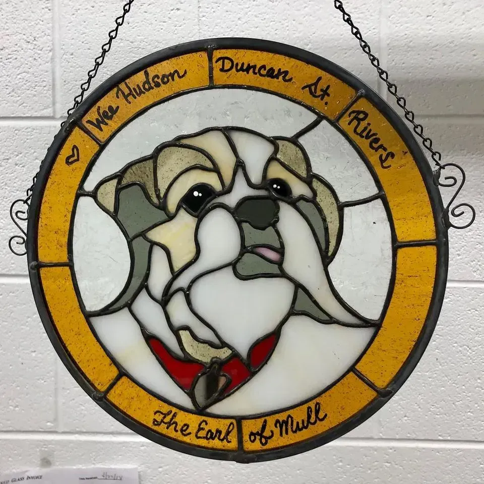 Stained glass bulldog art.  Yellow, white, and gray, with text 