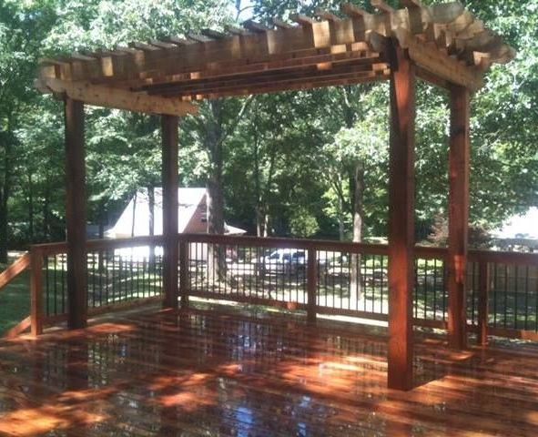 A wooden deck with a pergola on top of it