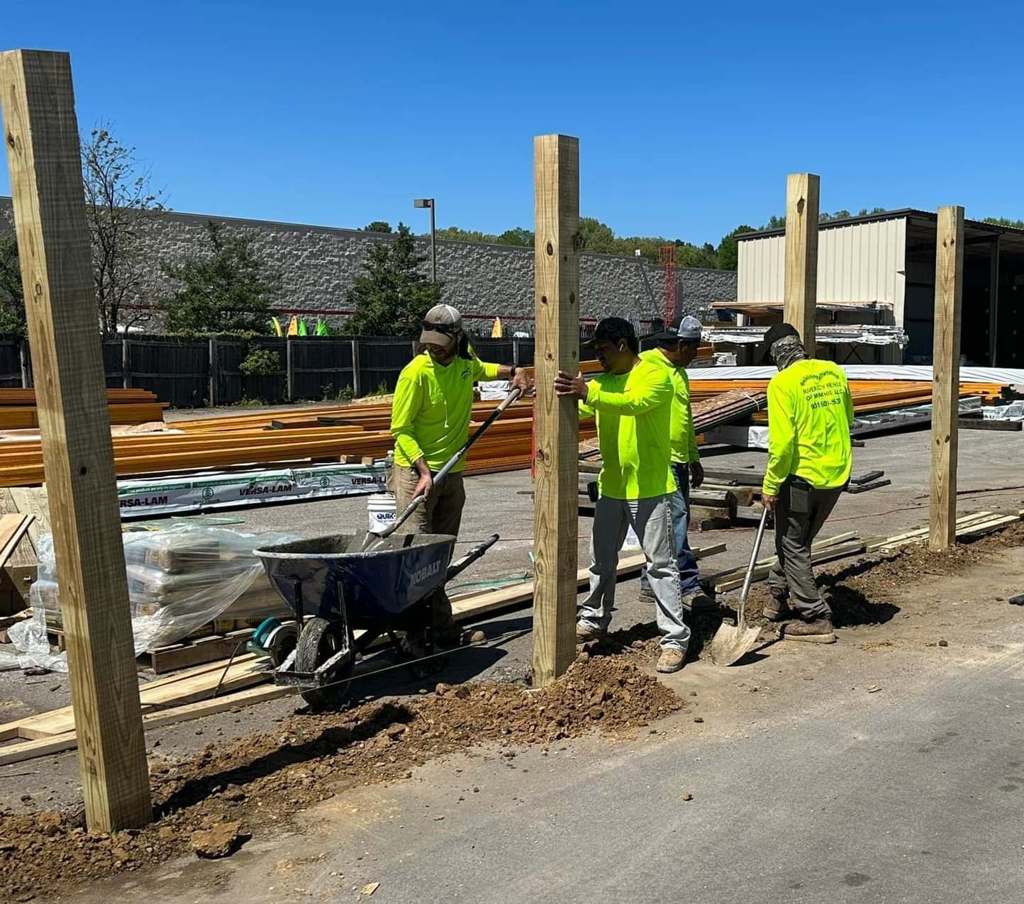 A group of construction workers are working on a wooden fence