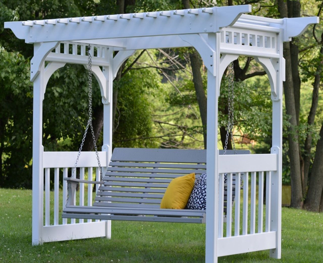 A white pergola with a swing underneath it