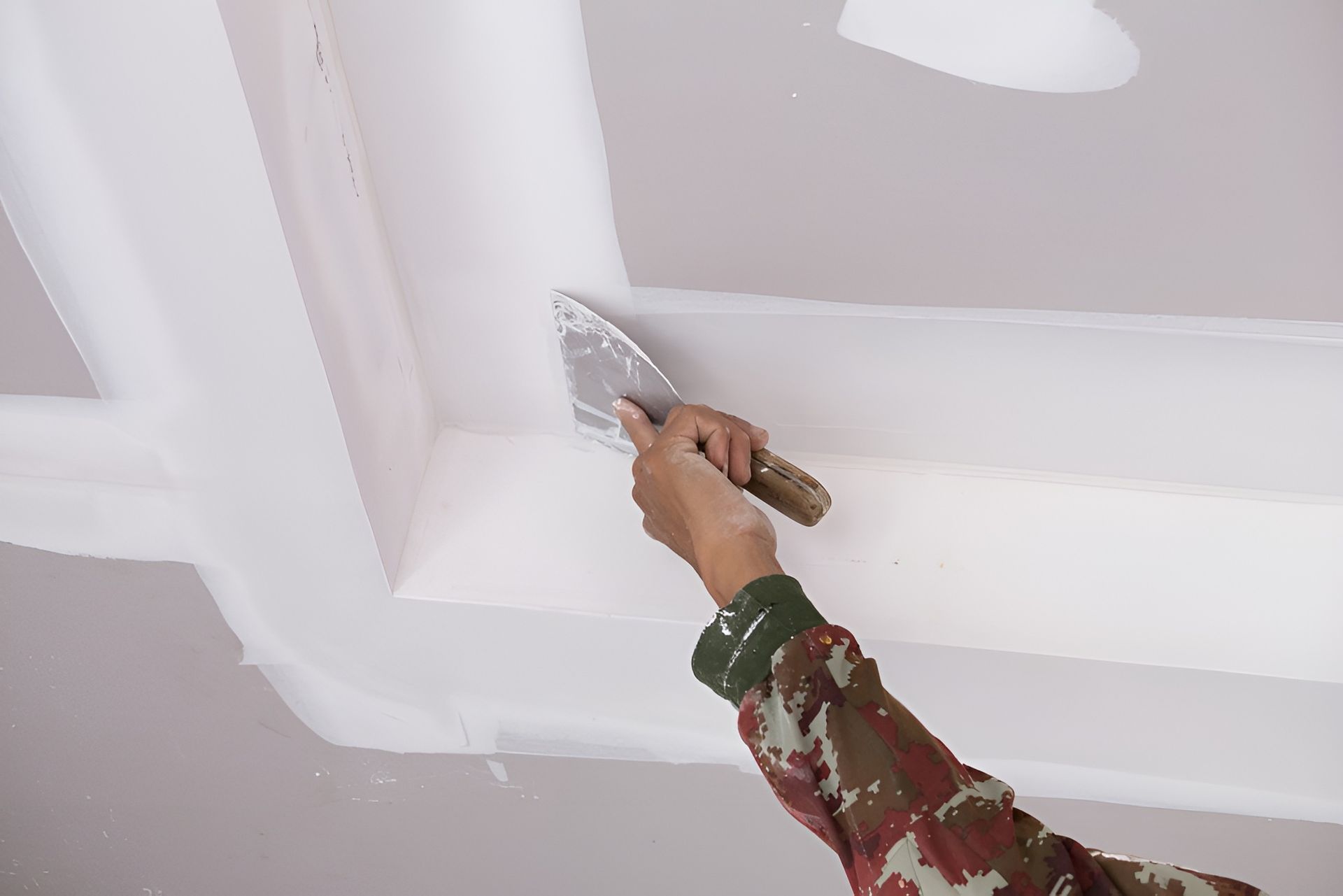 Hand Applying White Compound with A Trowel to A Ceiling Beam — Frenchy’s Plaster & Paint in Bellamack, NT