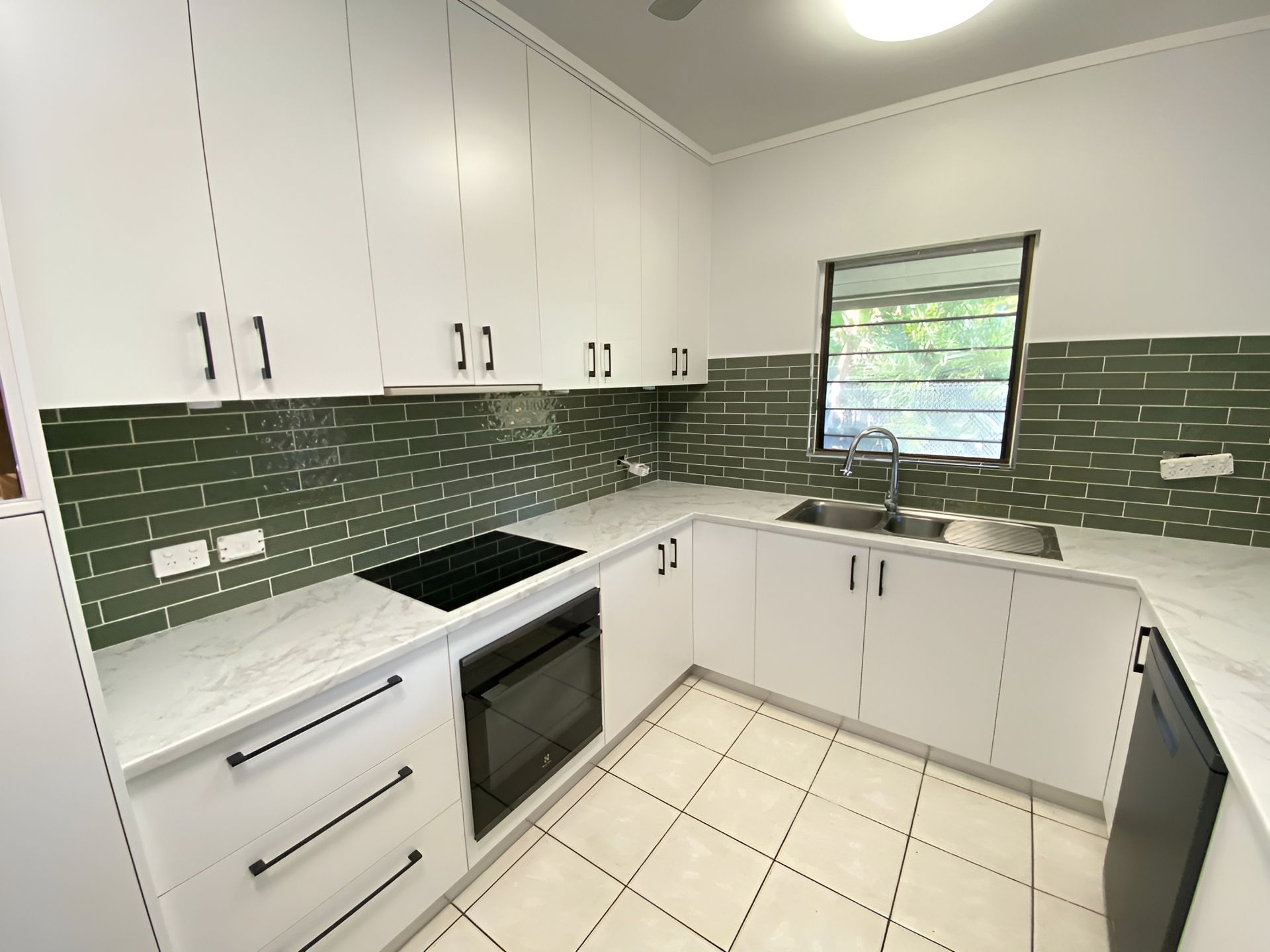 Modern White Kitchen with Green Tile Backsplash — Frenchy’s Plaster & Paint in Bellamack, NT