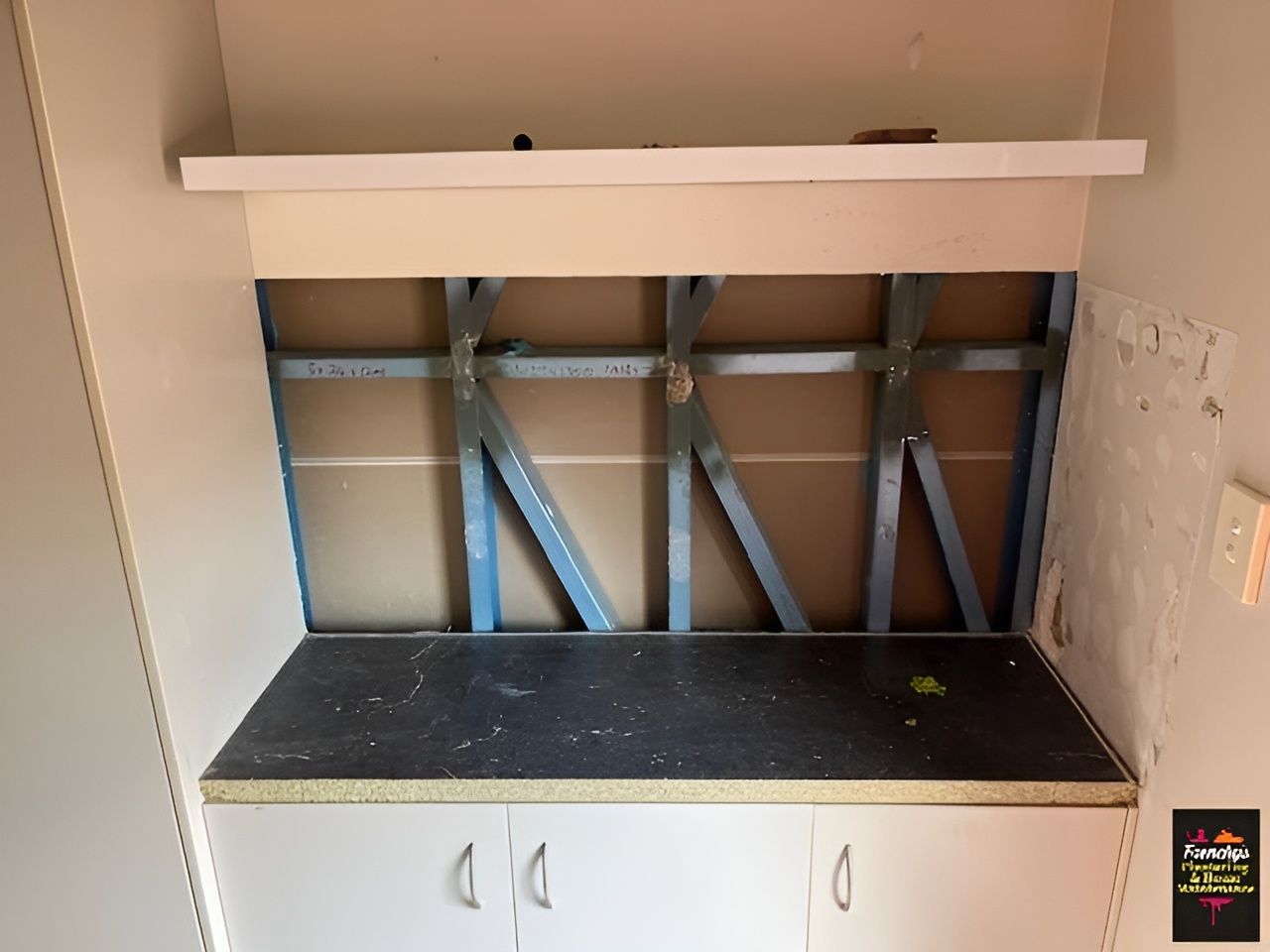 Cabinet with Countertop Under a Shelf, Drywall Removed to Reveal Metal Framing — Frenchy’s Plaster & Paint in Bellamack, NT