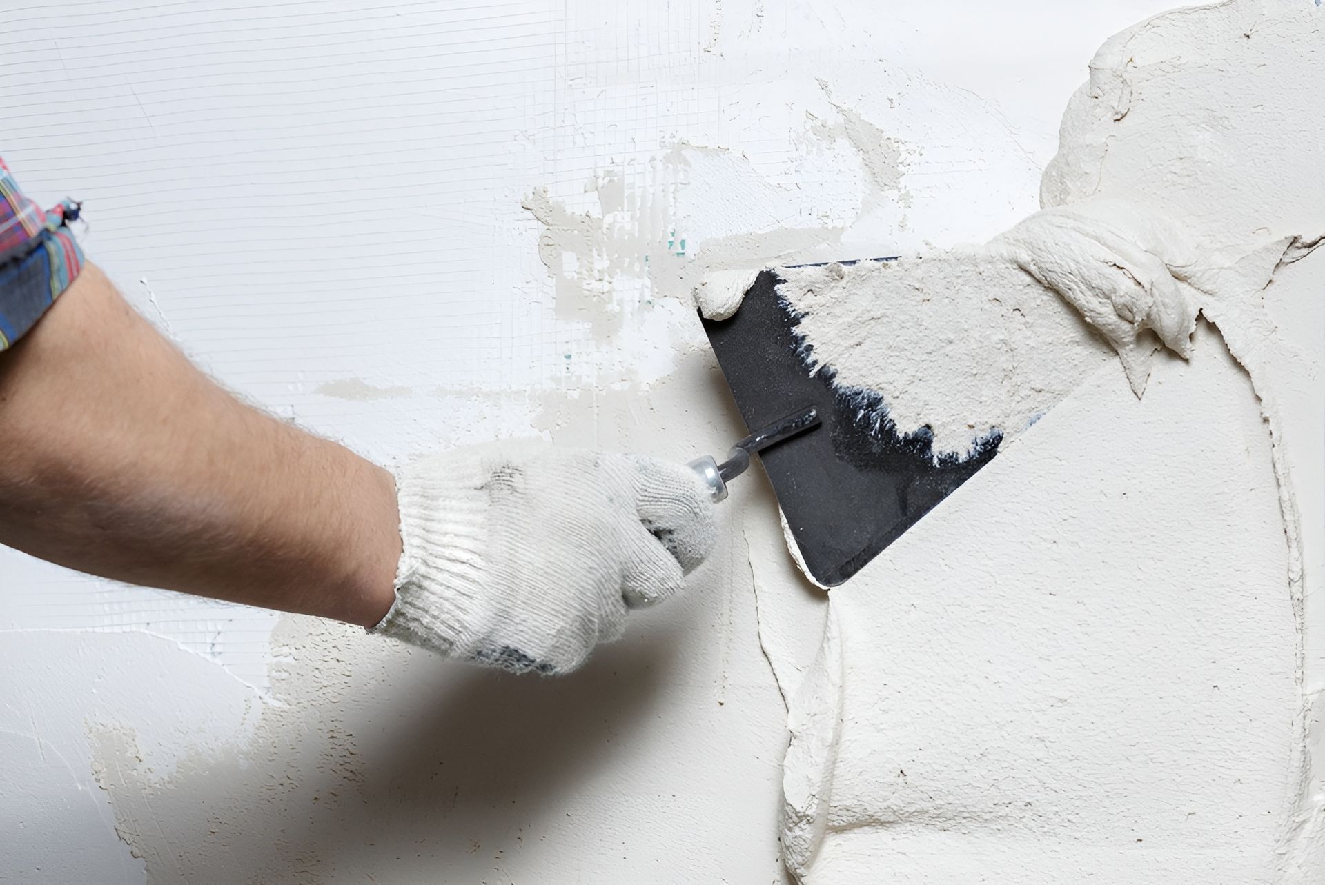 Person Using a Trowel to Apply Plaster to A White Wall — Frenchy’s Plaster & Paint in Bellamack, NT