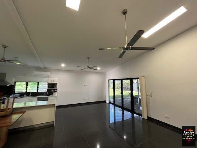 Open-concept living space with dark tile flooring, white walls, ceiling fans, and large glass doors leading outdoors. — Frenchy’s Plaster & Paint in Bellamack, NT