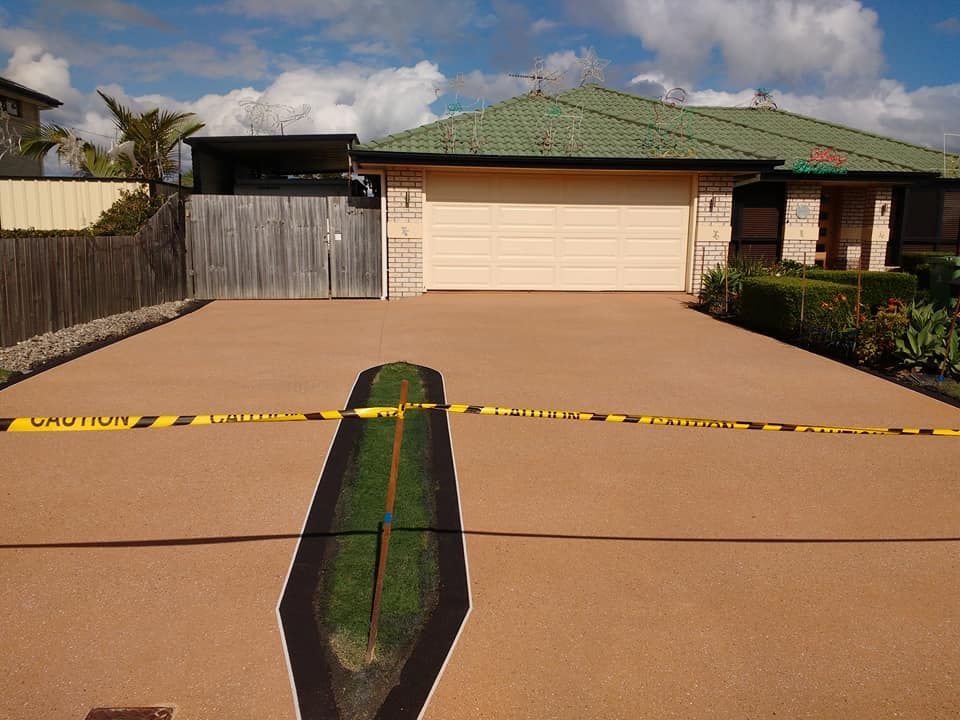 Red tiled patio with white grout under a wooden pergola.