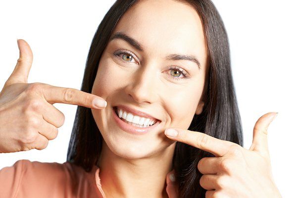 Woman pointing at her fixed implant dentures