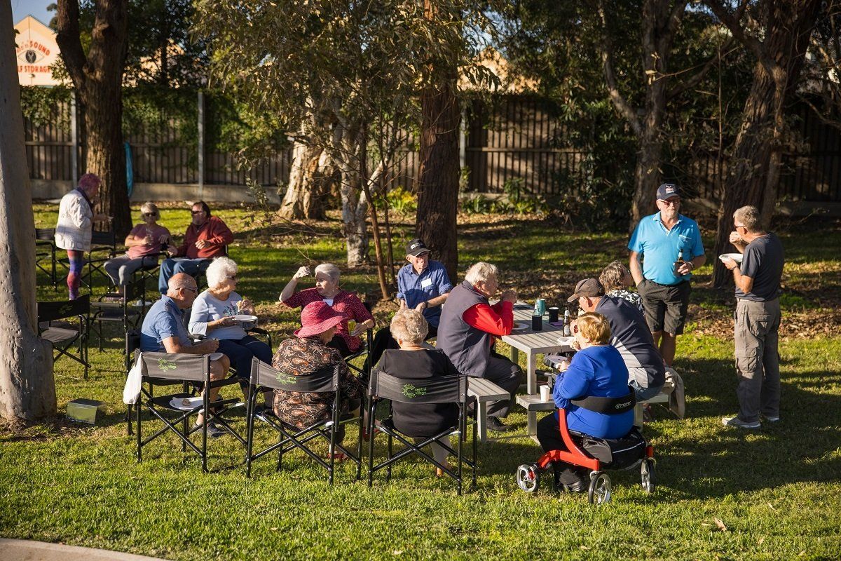 A group of people sitting outside together